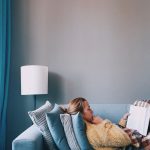 woman in white sweater lying on bed