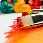 three silver paint brushes on white textile